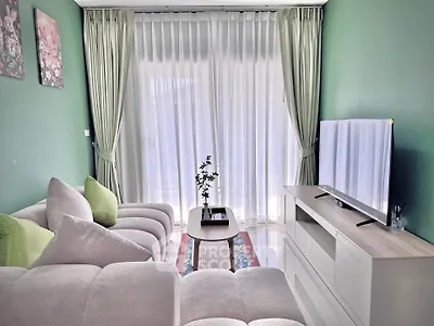 Stylish living room with plush sofa and large TV, perfect for relaxation.