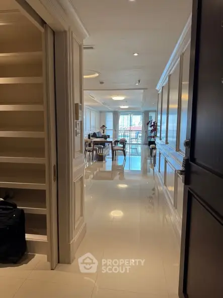 Luxurious apartment entrance leading to a spacious living area with elegant decor and bright lighting.