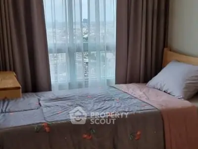 Cozy bedroom with city view, featuring a single bed and elegant curtains.