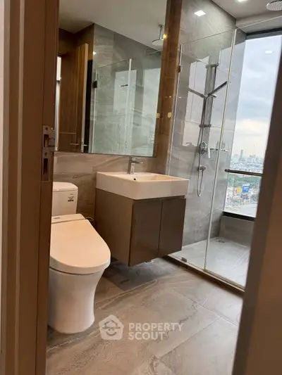Modern bathroom with sleek fixtures and city view from shower area.