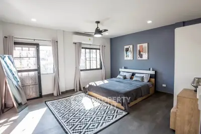 Spacious modern bedroom with stylish decor and large windows
