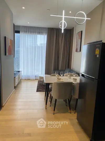 Modern open-layout kitchen and dining area with stylish lighting and sleek appliances.