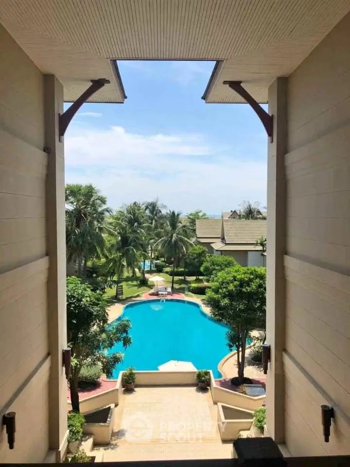 Stunning view of a luxurious pool surrounded by lush greenery and elegant architecture.