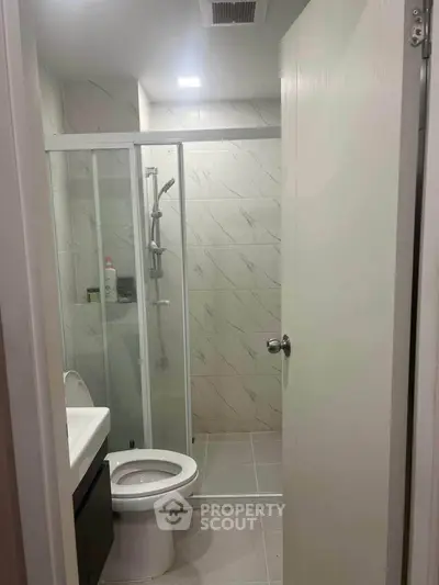 Modern bathroom with glass shower and sleek fixtures in a contemporary home.