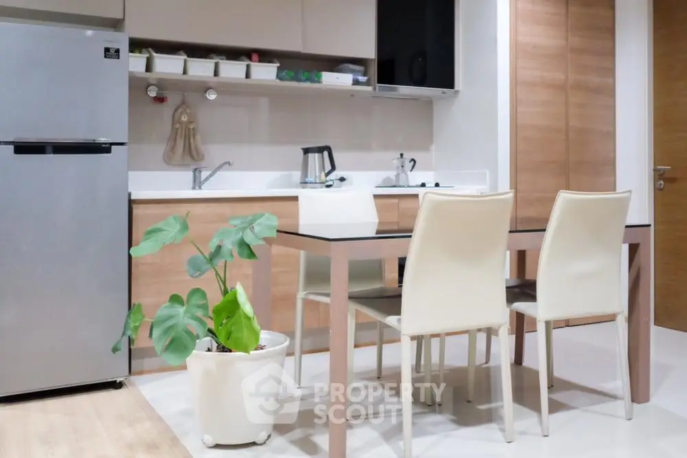 Modern kitchen with sleek cabinets and dining area in contemporary apartment