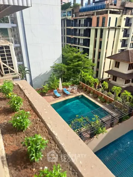 Stunning aerial view of a luxurious residential pool surrounded by lush greenery and modern architecture.