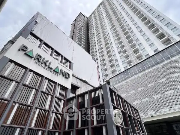 Modern high-rise building exterior with sleek architectural design and prominent entrance signage.