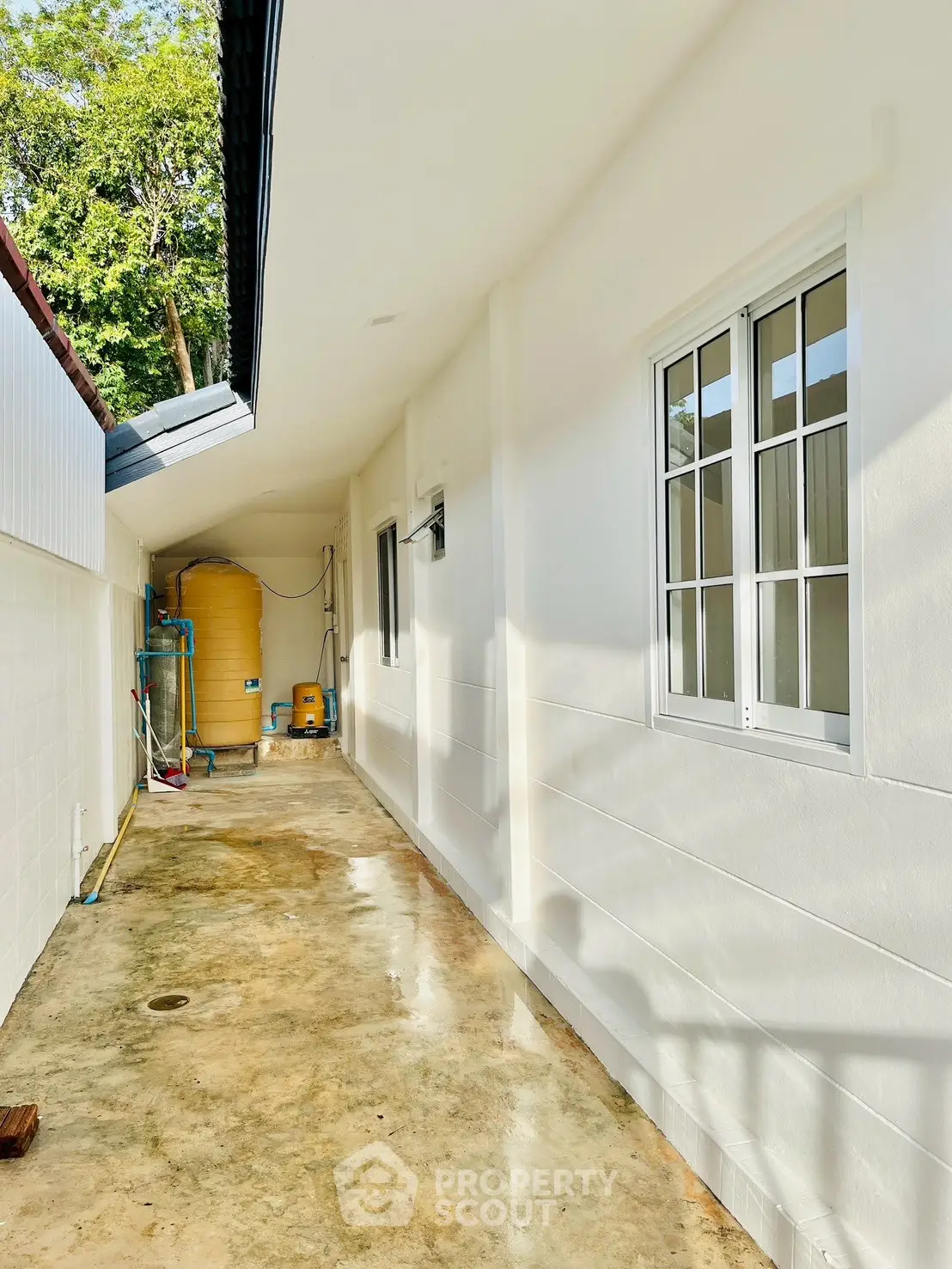 Bright exterior corridor with white walls and utility area