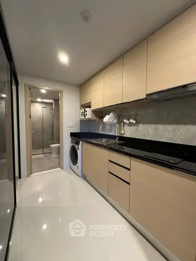 Modern kitchen with sleek cabinetry and integrated appliances in a stylish apartment.
