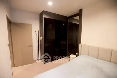 Modern bedroom with sleek black wardrobe and cozy bed in stylish apartment