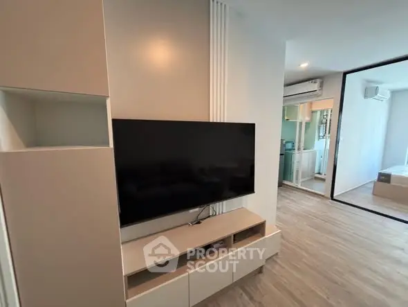 Modern living room with sleek TV setup and stylish storage cabinets.