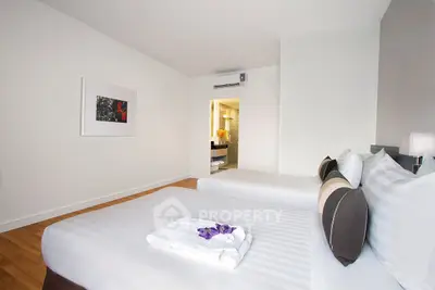 Spacious bedroom with modern decor and comfortable bedding in a stylish apartment.