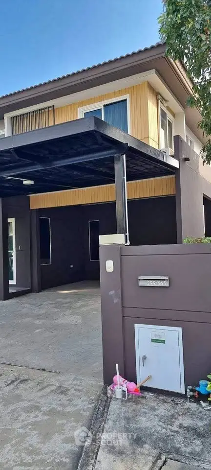 Modern two-story house with carport and contemporary design in a suburban neighborhood.