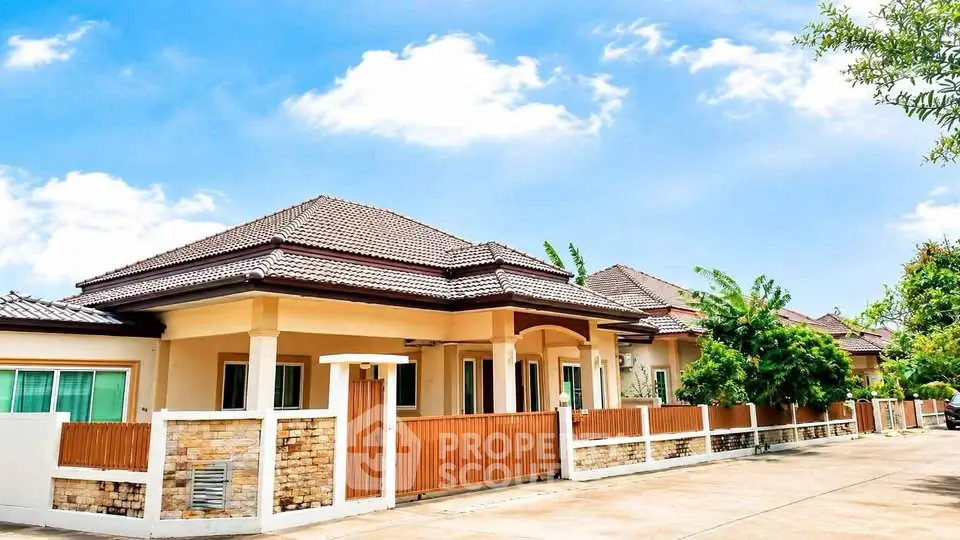 Charming suburban house with modern architecture and lush greenery under a clear blue sky.