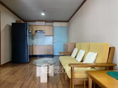Cozy living room with modern kitchen, featuring wooden flooring and stylish furniture.
