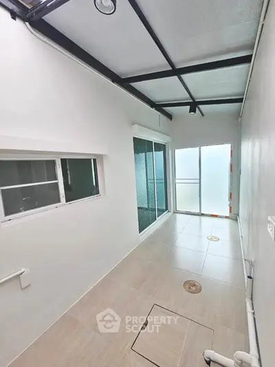 Spacious enclosed balcony with modern tiles and sliding glass doors