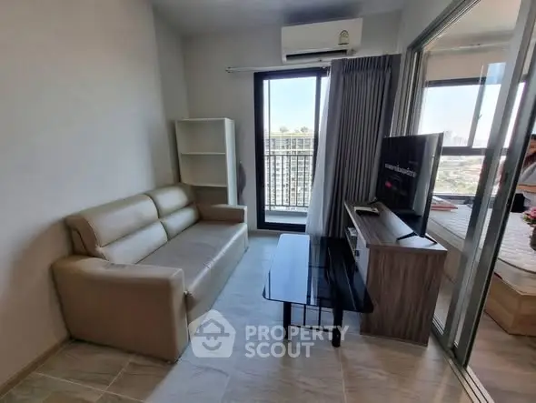 Modern living room with beige sofa, glass coffee table, and balcony view