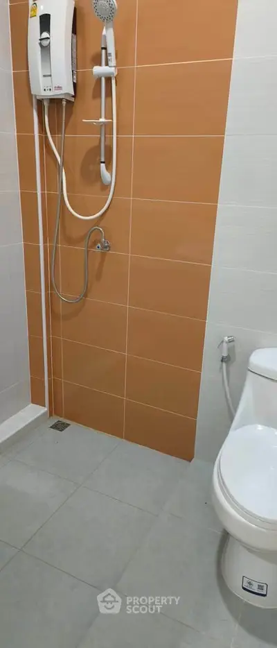 Modern bathroom with sleek shower and toilet in contemporary design.