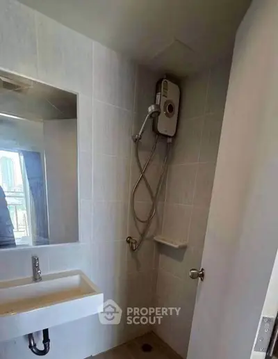 Modern bathroom with sleek shower and sink, featuring a city view from the window.
