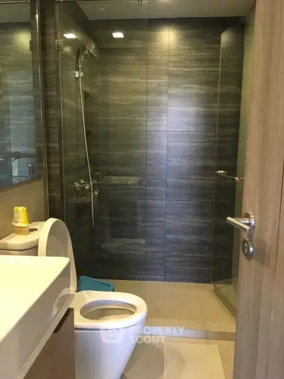 Modern bathroom with sleek design and glass shower enclosure in a contemporary apartment.