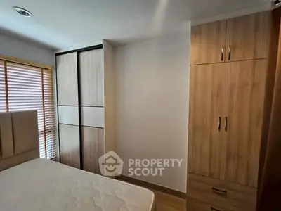 Cozy bedroom with modern wooden wardrobe and natural light