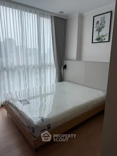 Modern bedroom with large window and city view, featuring a sleek bed and stylish decor.