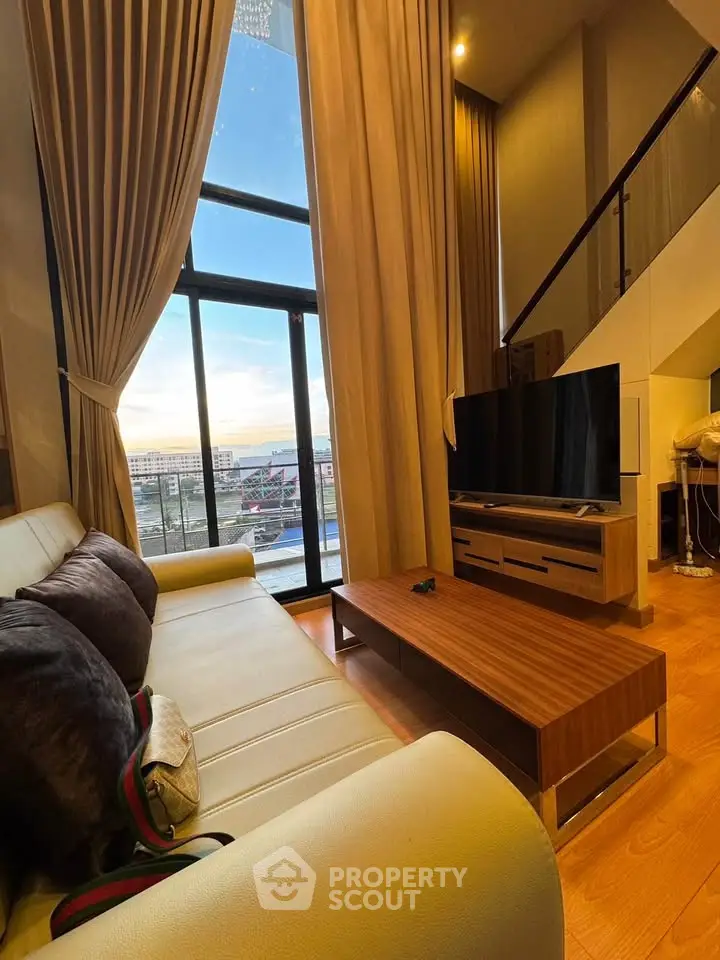Luxurious living room with high ceilings and stunning city view through large windows.