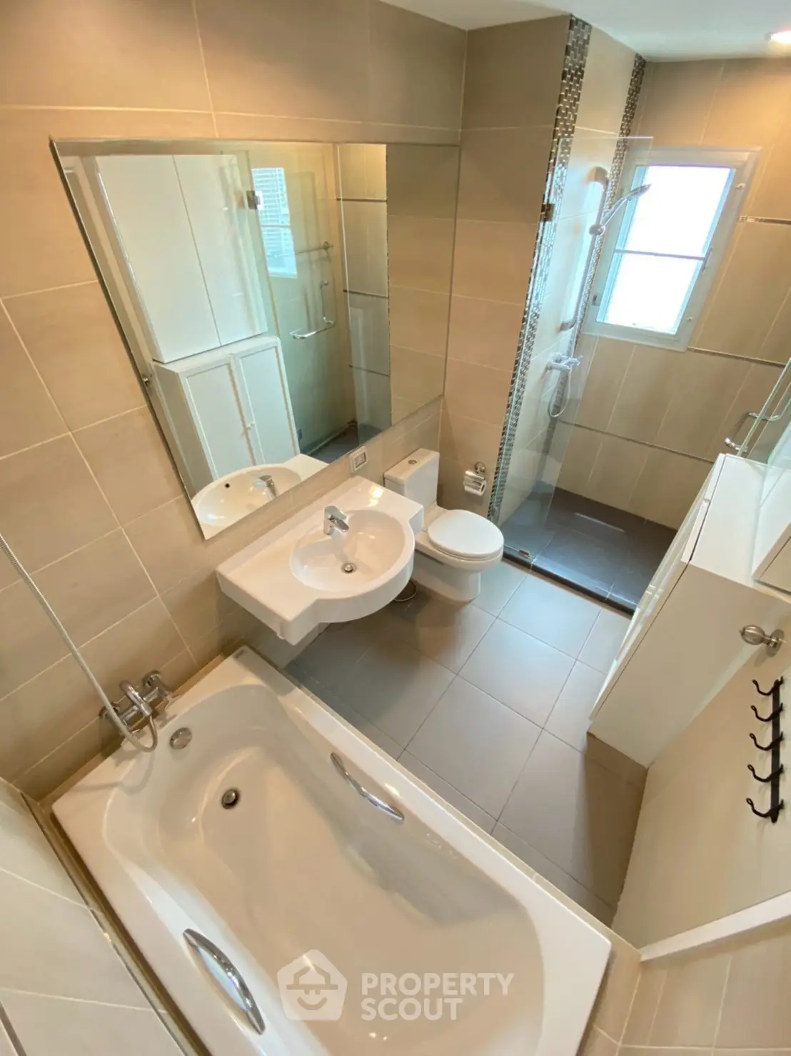 Modern bathroom with bathtub and shower in elegant beige tiles