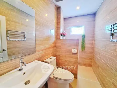 Modern bathroom with sleek fixtures and stylish tile design, featuring a large mirror and natural light.