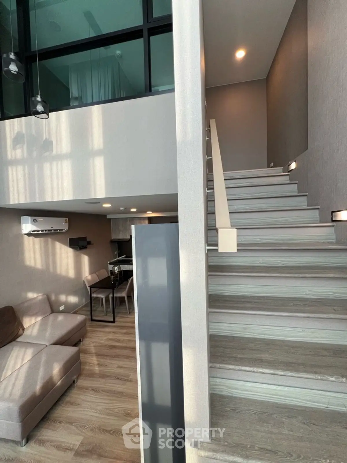 Modern duplex apartment with stylish staircase and cozy living area