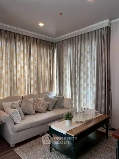 Cozy living room with elegant curtains and plush sofa, perfect for relaxation.