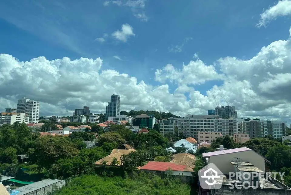 Stunning cityscape view with lush greenery and modern buildings under a vibrant blue sky.