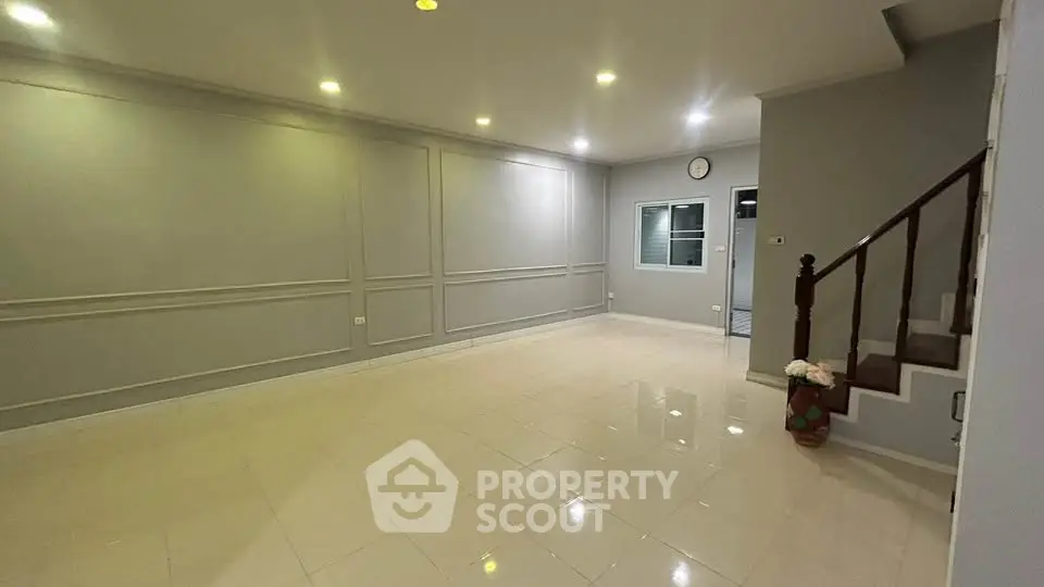 Spacious living room with elegant lighting and tiled flooring, perfect for modern living.