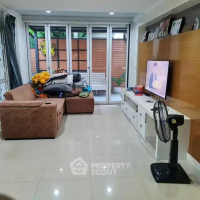 Spacious living room with modern decor and large sliding glass doors leading to a cozy outdoor area.