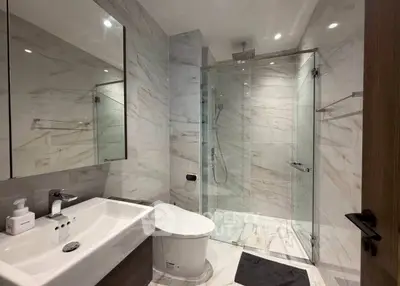 Luxurious modern bathroom with marble tiles and glass shower enclosure