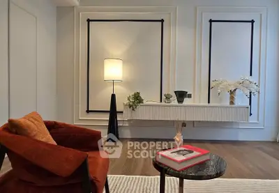 Stylish living room with modern decor, featuring a cozy armchair and elegant lighting.