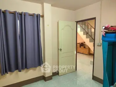 Cozy interior with staircase and blue curtains, ideal for a small family home.