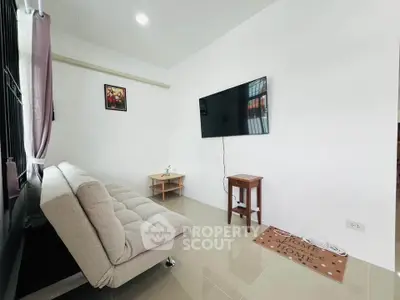 Cozy living room with modern sofa and wall-mounted TV, perfect for relaxation.