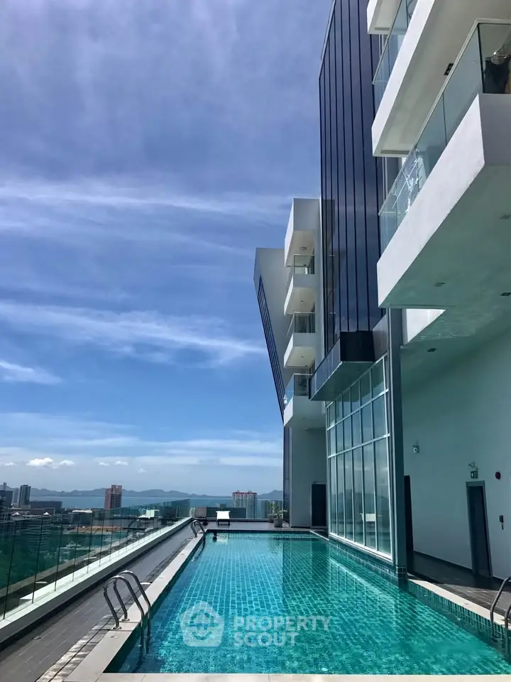Stunning rooftop pool with panoramic city views in modern high-rise building.