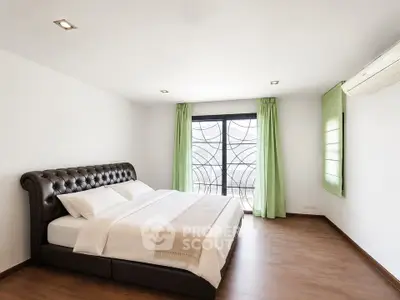 Spacious modern bedroom with elegant decor and large window for natural light.