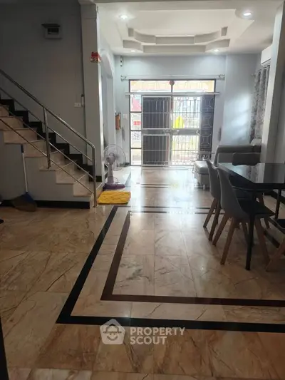 Spacious living room with elegant marble flooring and modern dining area