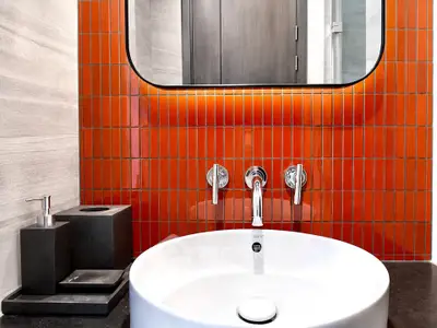 Modern bathroom with vibrant orange tiles and sleek fixtures