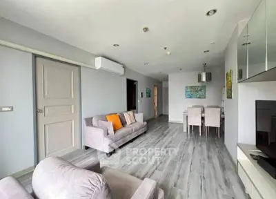 Spacious modern living room with stylish decor and dining area, perfect for comfortable living.