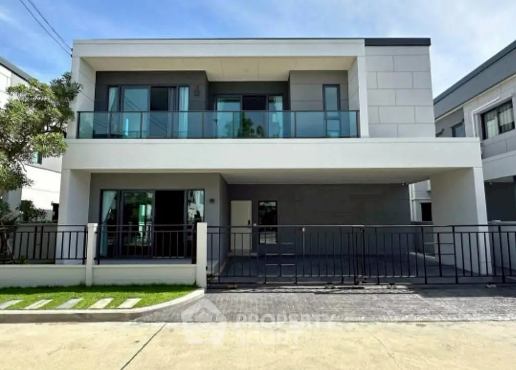 Modern two-story house with glass balcony and spacious driveway