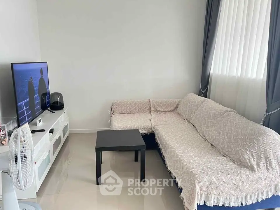 Cozy living room with modern TV setup and stylish curtains