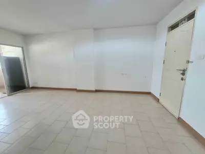 Spacious empty room with tiled flooring and natural light, ideal for customization.