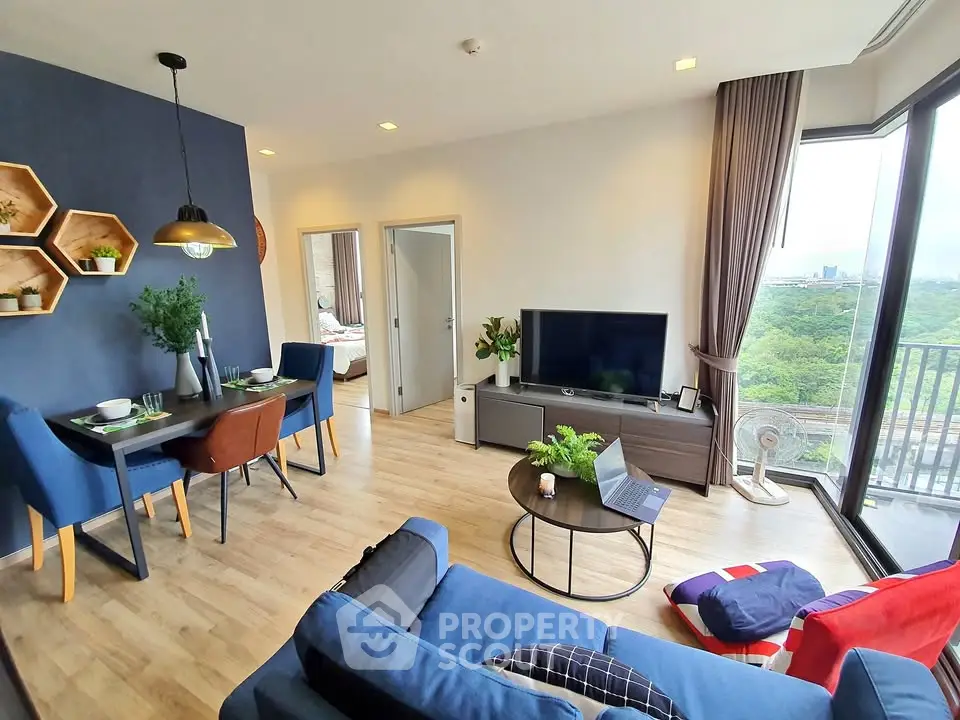 Modern living room with stylish decor and large windows offering a stunning view of greenery.