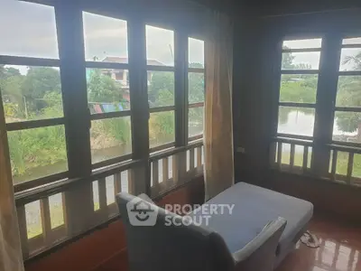 Charming living room with large windows offering serene water views, perfect for relaxation and tranquility.