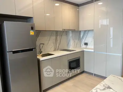Modern kitchen with sleek cabinetry and built-in appliances in a stylish apartment.