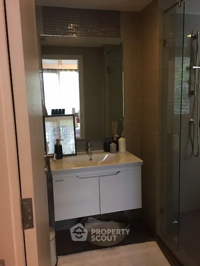 Modern bathroom with sleek vanity and glass shower in contemporary apartment.